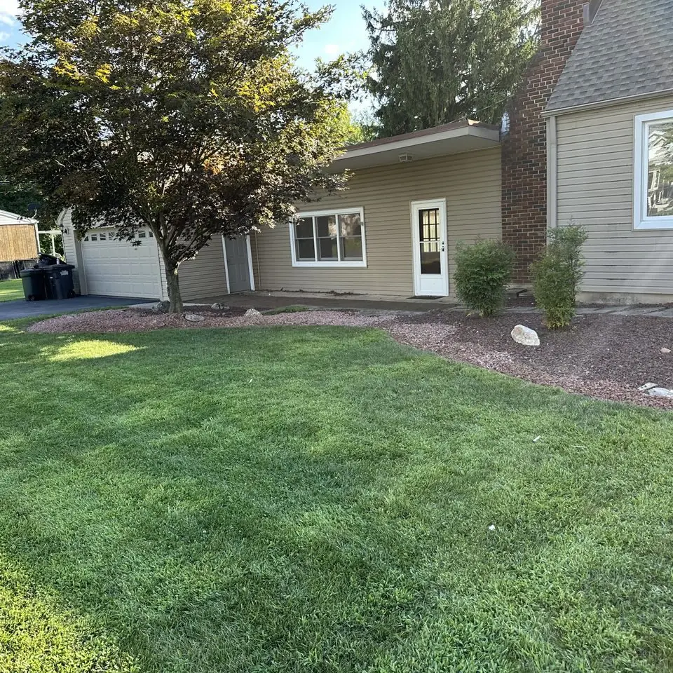 Front lawn with tidy mulched beds beside a ranch-style home