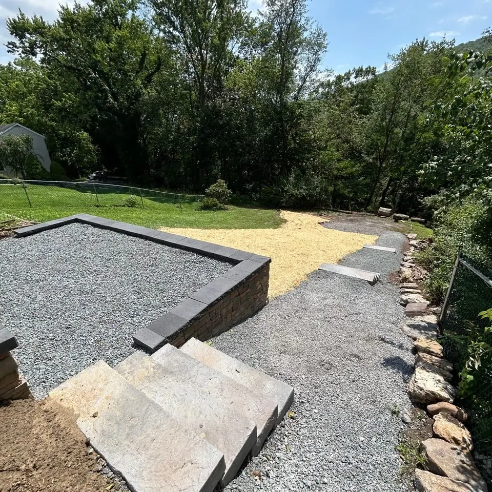 Gravel base and stone steps prepared for a backyard hardscape project