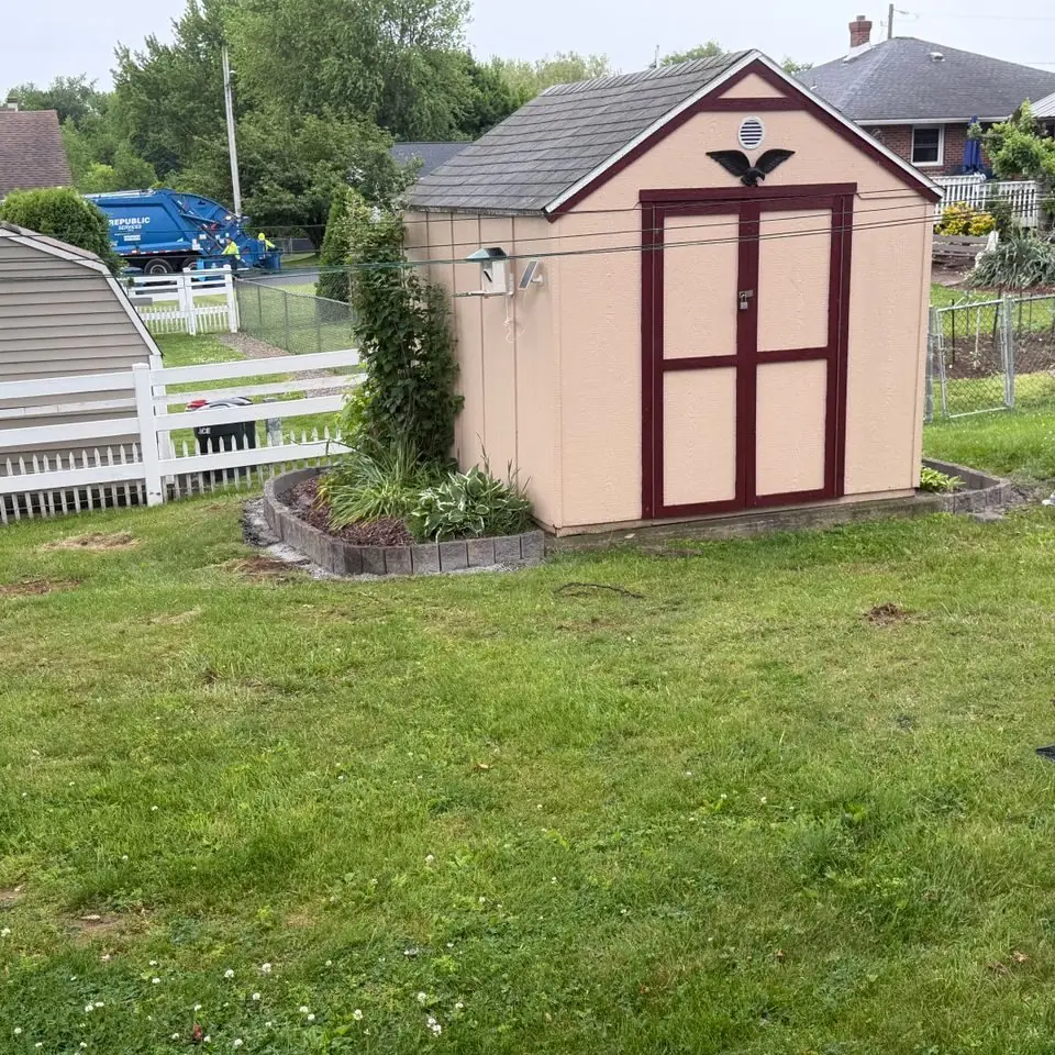 Small shed with a landscaped bed and lawn in a backyard